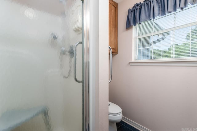 bathroom featuring tile patterned flooring, a shower with shower door, and toilet