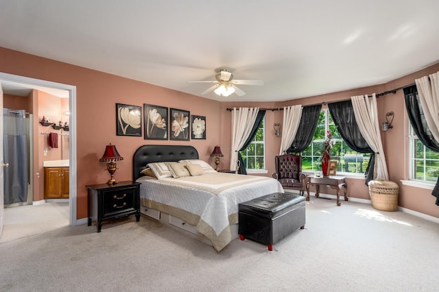 carpeted bedroom featuring ensuite bath and ceiling fan