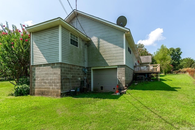 rear view of house with a garage, a yard, and a deck