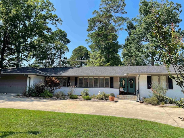 ranch-style home featuring a garage and a front yard