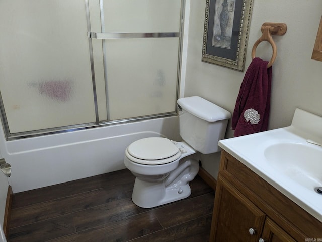 full bathroom featuring vanity, bath / shower combo with glass door, toilet, and hardwood / wood-style flooring