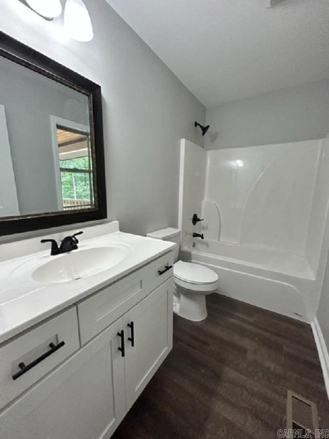 full bathroom featuring vanity, wood-type flooring, bathing tub / shower combination, and toilet