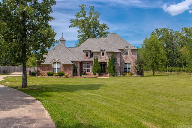 french country inspired facade with a front lawn