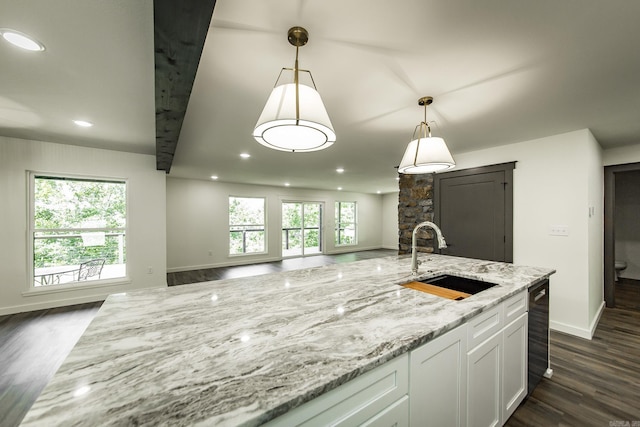 kitchen featuring sink, pendant lighting, white cabinets, and light stone counters