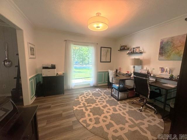 office area with a wainscoted wall, crown molding, and wood finished floors