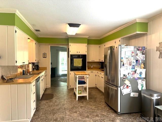 kitchen featuring light countertops, freestanding refrigerator, oven, and a sink