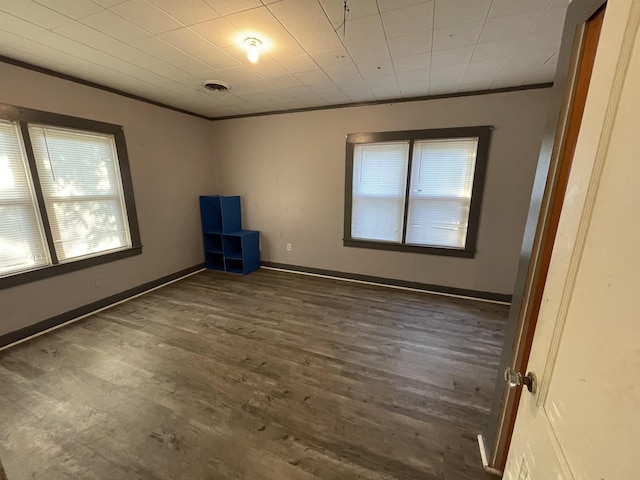 spare room with dark hardwood / wood-style flooring and crown molding