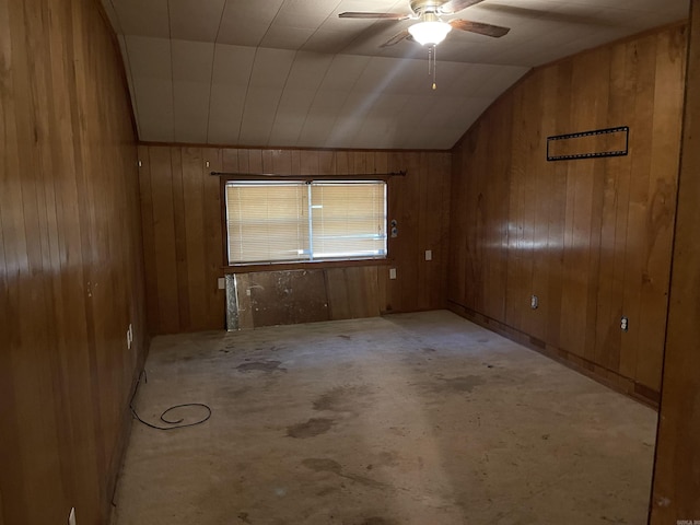 spare room with ceiling fan, lofted ceiling, and wooden walls