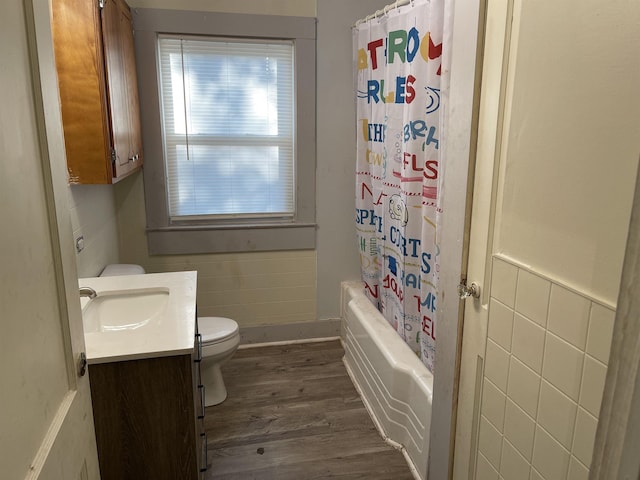 full bathroom featuring tile walls, vanity, wood-type flooring, toilet, and shower / bath combo with shower curtain