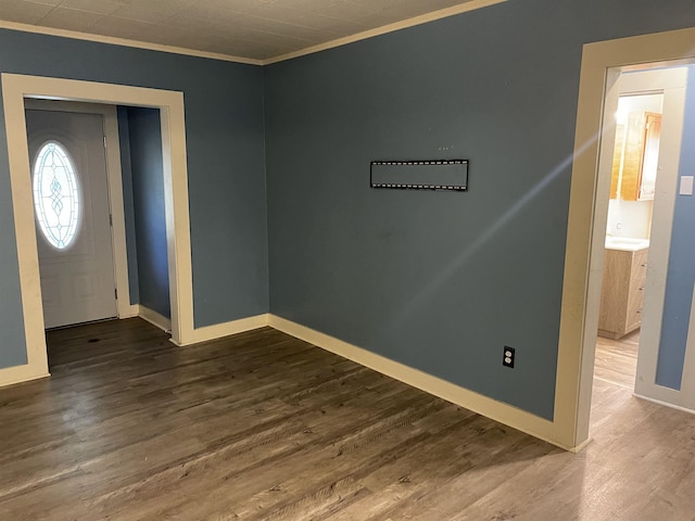 foyer entrance with ornamental molding and hardwood / wood-style floors