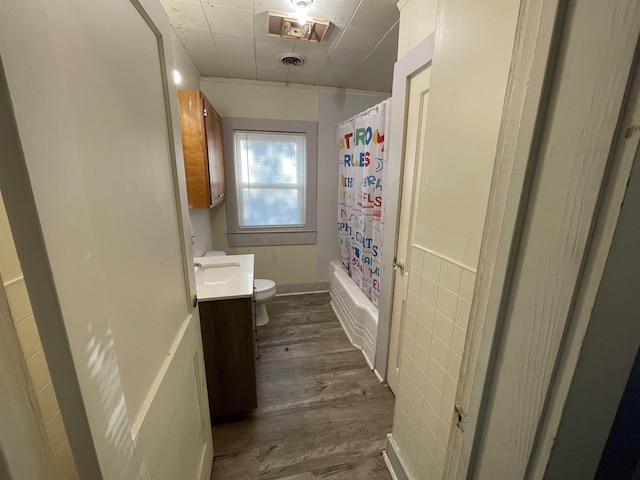 full bathroom featuring vanity, wood-type flooring, shower / tub combo with curtain, and toilet