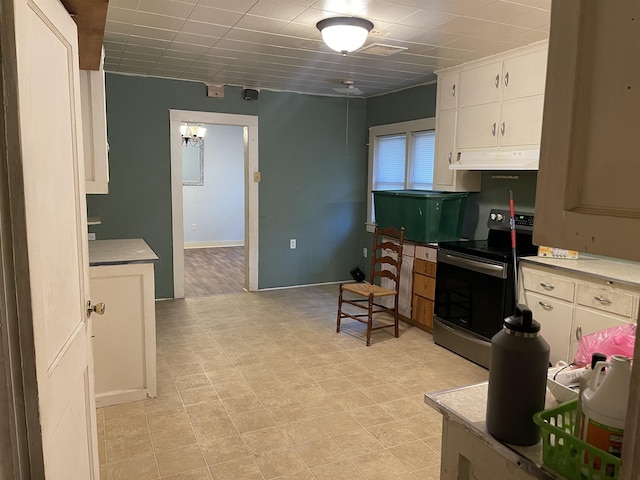 kitchen featuring stainless steel electric stove and white cabinets