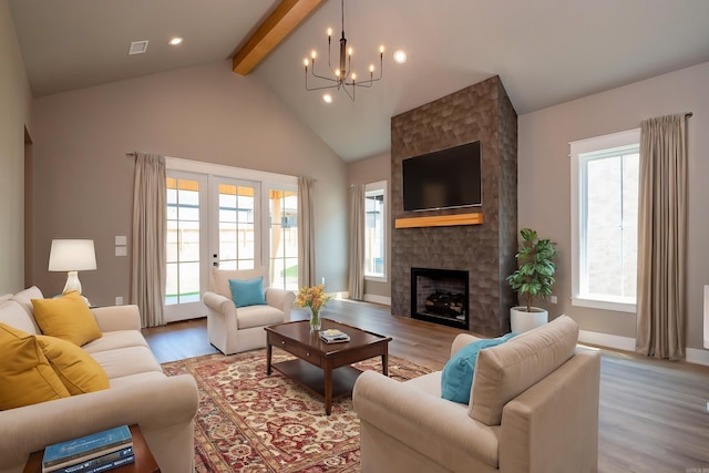 living room featuring light hardwood / wood-style flooring, a fireplace, plenty of natural light, and beamed ceiling