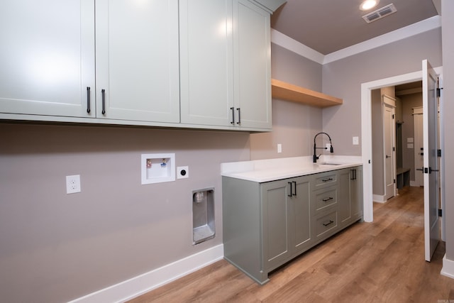 clothes washing area featuring sink, electric dryer hookup, cabinets, washer hookup, and light wood-type flooring