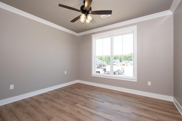 spare room featuring wood-type flooring, ornamental molding, and ceiling fan