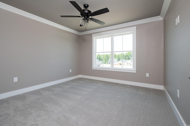 empty room featuring crown molding, light colored carpet, and ceiling fan