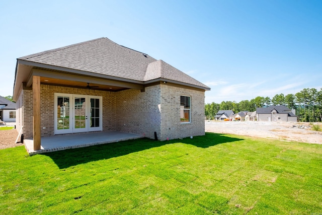 rear view of house with french doors, ceiling fan, a patio area, and a lawn