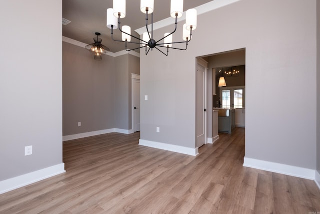 unfurnished dining area with a chandelier and light hardwood / wood-style floors