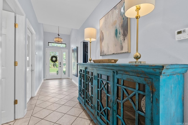 hall with vaulted ceiling and light tile patterned floors