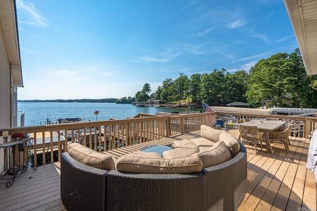 deck with outdoor lounge area and a water view