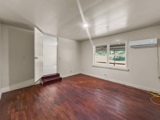 empty room with dark hardwood / wood-style floors and a wall mounted AC