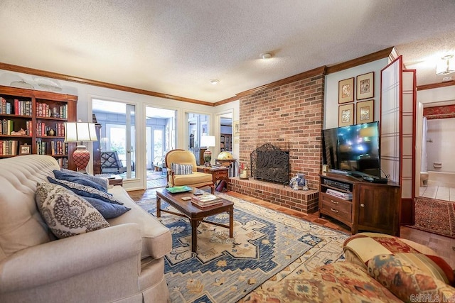 living room with crown molding, wood-type flooring, a textured ceiling, and a brick fireplace