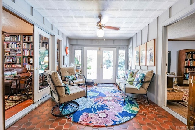 sunroom / solarium featuring ceiling fan and french doors