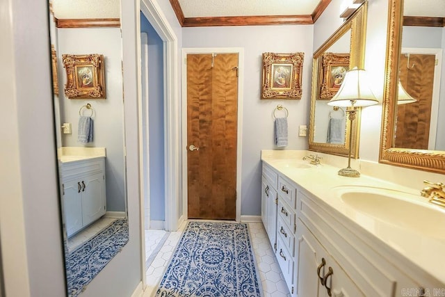 bathroom with dual vanity, crown molding, a textured ceiling, and tile patterned flooring