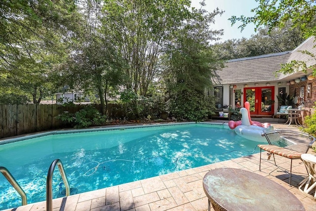 view of swimming pool featuring french doors and a patio area