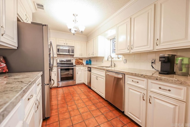 kitchen featuring light tile patterned floors, backsplash, ornamental molding, stainless steel appliances, and sink