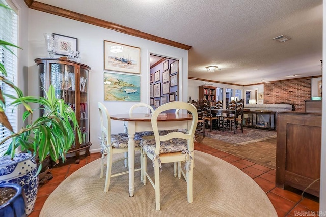 tiled dining space with a textured ceiling, brick wall, and crown molding