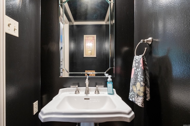 bathroom with crown molding and sink