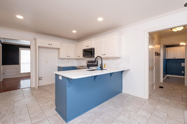 kitchen featuring white cabinets, blue cabinets, appliances with stainless steel finishes, and sink