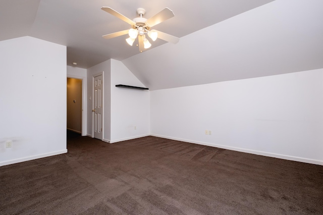 additional living space featuring lofted ceiling, dark colored carpet, and ceiling fan