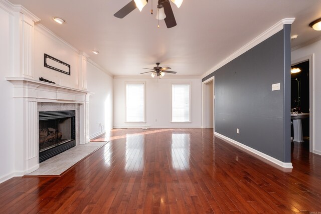 living room featuring ceiling fan, hardwood / wood-style floors, crown molding, and a fireplace