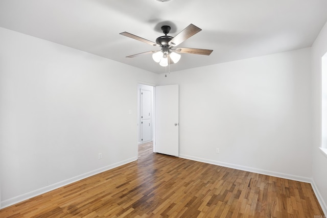 unfurnished room featuring ceiling fan, baseboards, and wood finished floors