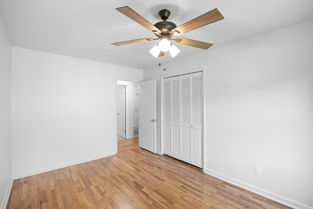 unfurnished bedroom with light wood finished floors, a ceiling fan, baseboards, and a closet