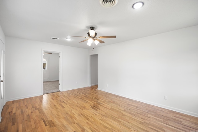 unfurnished room with baseboards, visible vents, ceiling fan, and light wood finished floors