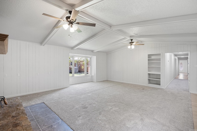 unfurnished living room featuring a textured ceiling, carpet floors, and built in features