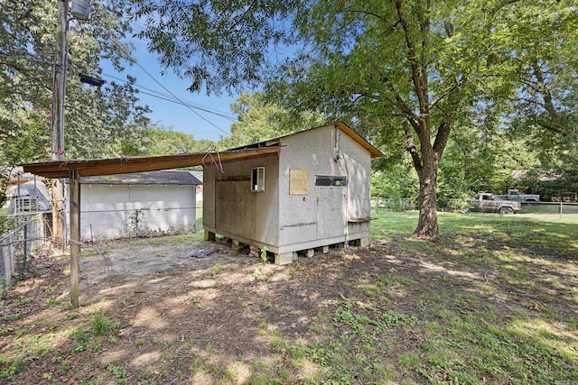 view of outbuilding with fence and an outbuilding