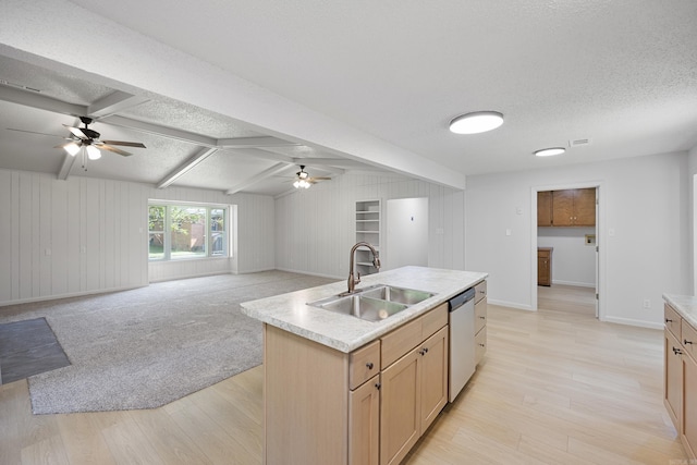 kitchen with stainless steel dishwasher, a textured ceiling, open floor plan, and a sink