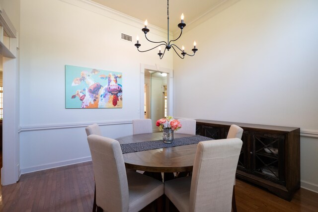 dining area with a notable chandelier, ornamental molding, and dark hardwood / wood-style floors