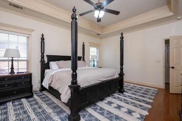 bedroom featuring ceiling fan, a raised ceiling, ornamental molding, and light hardwood / wood-style floors