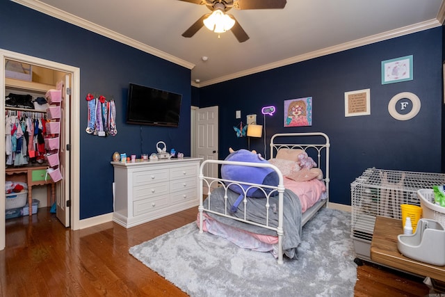 bedroom with ceiling fan, wood-type flooring, a closet, and ornamental molding