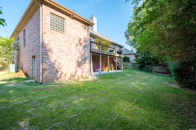 rear view of house featuring cooling unit and a lawn