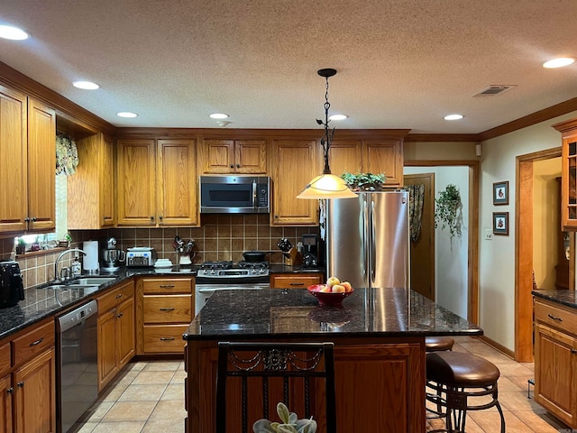 kitchen with stainless steel appliances, light tile patterned floors, a center island, tasteful backsplash, and sink