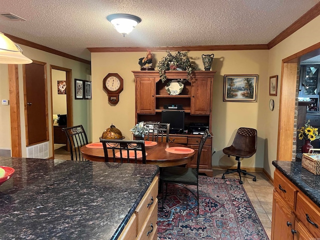 tiled dining area with ornamental molding and a textured ceiling