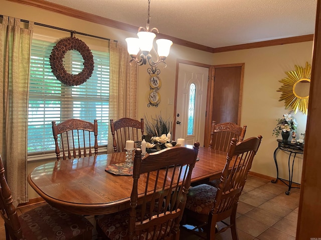 dining area featuring a textured ceiling, ornamental molding, a chandelier, and tile patterned flooring