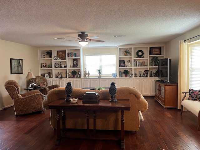 living room with ceiling fan, dark hardwood / wood-style floors, and a textured ceiling