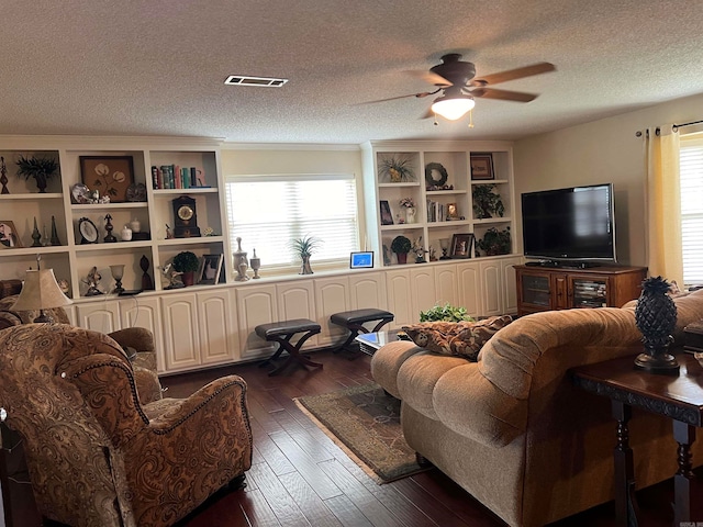 living room featuring a textured ceiling, dark hardwood / wood-style flooring, and ceiling fan